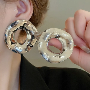 Boucles d'oreilles géométriques en argent avec texture martelée portées par un mannequin