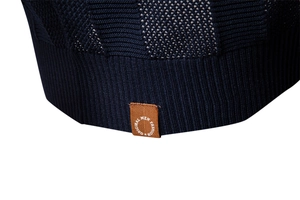 Macro shot of navy knit polo shirt showing ribbed hem detail and fashion brand label