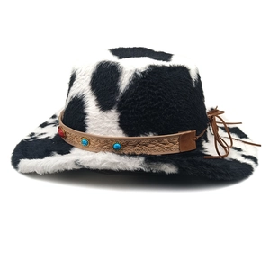 Détail d'un chapeau de cow-boy en peluche à motif vache avec bande ethnique et perles