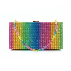 Macro detail of vibrant rainbow rhinestones and gold hardware on a luxury clutch bag