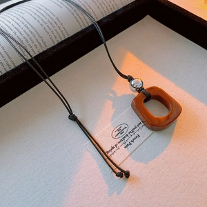 Irregular hollow pendant on black cord shown in a lifestyle setting with warm sunlight