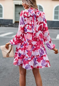 Détail de la robe fleurie rose à volants avec un nœud élégant au dos et jupe à plusieurs niveaux