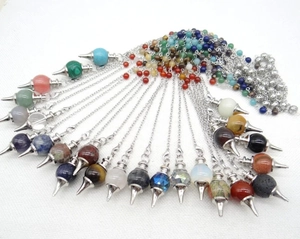 Detailed macro view showing a wide variety of natural stone dowsing crystal pendants