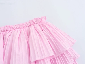 Close-up of pink layered ruffle skirt showing elastic waistband and pleated fabric texture