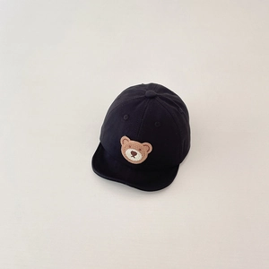 Detail view of baby soft brim baseball cap with cute brown crochet bear patch on black cotton