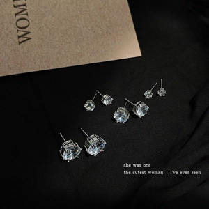 Detailed view of four pairs of sparkling zircon stud earrings in various sizes on black fabric