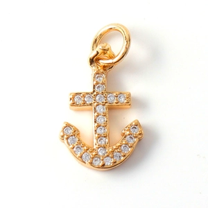 Macro shot of gold anchor charm with sparkling rhinestones and an open ring for jewelry