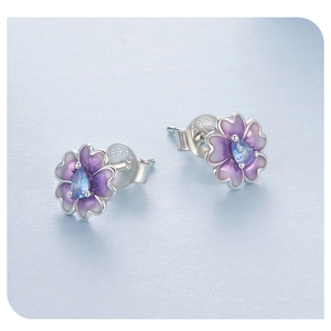 Detailed macro view of S925 sterling silver cherry blossom studs with blue gemstones