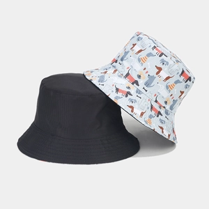 Detail of reversible bucket hat showing cartoon dog print and classic black solid color