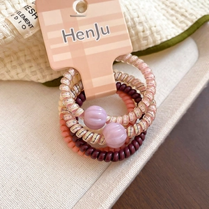 Detail of colorful hair ties set with heart star charms on a branded display card
