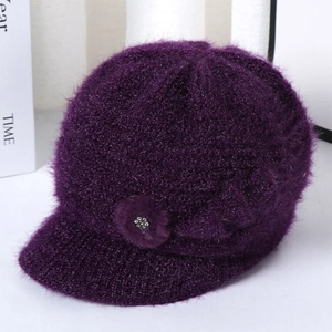 Detail of purple knitted hat for elderly women with plush flower and rhinestone accent