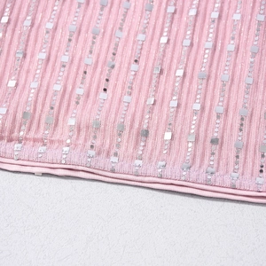 Gros plan sur un tissu côtelé rose avec paillettes argentées et coutures détaillées