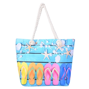 Détail du sac de plage avec poignées en corde de coton et motifs estivaux sur toile
