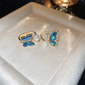 Detailed macro view of gold plated butterfly ring with abalone shell and pearl accents