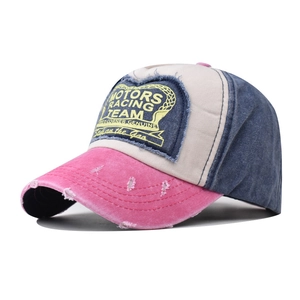Close-up of distressed denim baseball cap with heart-shaped Motors Racing Team patch