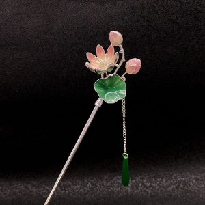Dettaglio del fermaglio per capelli a loto rosa con foglie smaltate e nappine oro