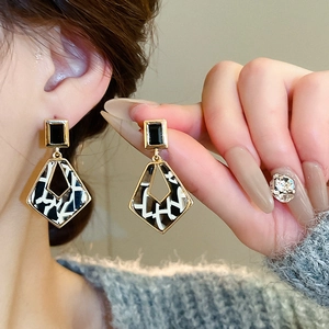 Gros plan de boucles d'oreilles carrées en acétate léopard avec diamants pour femmes