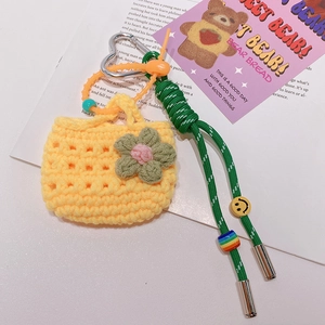Vue détaillée d'un mini sac porte-clés au crochet jaune avec fleurs et lanière perlée