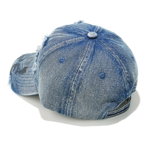 Detailed macro view of distressed dark blue denim baseball cap with frayed edges