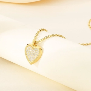 Macro shot of gold-plated heart pendant with shimmering pave-set white zircons