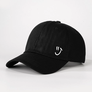 Detail shot of the black cotton baseball cap showing side white embroidered smiley face