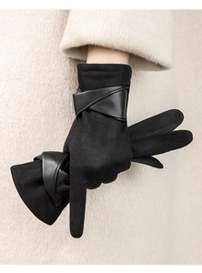 Détail de gants en daim noir avec sangle en cuir croisée élégante sur le poignet