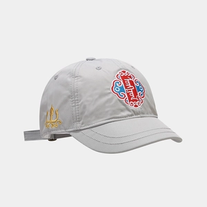 Vue détaillée d'une casquette gris clair avec broderie ethnique rouge et motifs dorés
