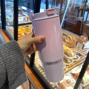 Close-up of a 30oz lavender insulated tumbler with a pink handle lid in a lifestyle setting