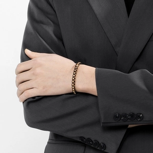 Nahaufnahme eines braunen Herren-Lederarmbands mit Metallgliedern an einem Handgelenk