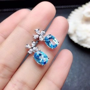 Elegante bloemoorbellen met blauwe zirkoon en een verzilverde zetting voor dames
