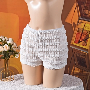Détail d'un short blanc en dentelle à volants avec un nœud en satin et texture multicouche