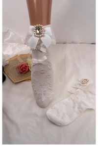 Detailed view of white Lolita lace socks featuring a delicate bow and rhinestone pearl accents