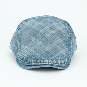 Detail of light blue washed denim flat cap featuring classic quilted diamond patterns