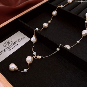 Macro detail of French vintage baroque pearls on a fine gold plated necklace chain