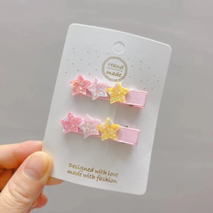 Close-up of glitter star hair clips set for girls on a white card display