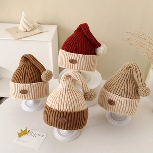 Baby winter knit pointed beanies with pom-poms and leather patches in four warm colors