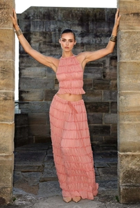 Detail of pink chiffon halter top and pleated maxi skirt set in an architectural setting