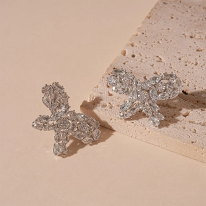 Detailed view of butterfly stud earrings with marquise-cut zircons on a stone pedestal