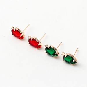 Detail of 14k gold plated zircon stud earrings featuring red and green marquise cut stones