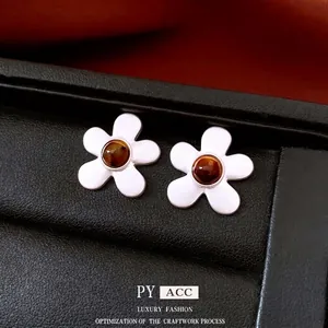 Elegant silver flower earrings with brown gemstone inlay in a black jewelry box