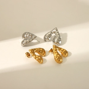 Vue macro de boucles d'oreilles en forme de cœur à texture lave en fini or et argent