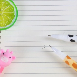 Close-up of cute giraffe pattern gel pens writing on a lined notebook page