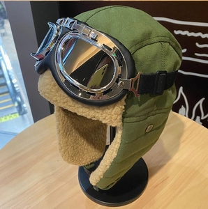 Dettaglio del cappello da aviatore verde militare con fodera in pile e occhiali