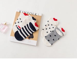 Flat lay of five pairs of cotton socks with stripes and heart details on Kinfolk magazine