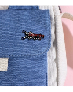 Detail einer Dopamin-Molekül-Emaille-Anstecknadel an einer blau-weißen Canvas-Tasche