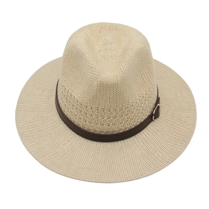 Detail eines beige Strohhuts mit dunkelbraunem Kunstlederband und metallischer Schnalle