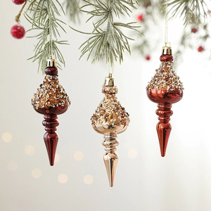 Three-piece champagne and burgundy beaded Christmas finial ornaments hanging on tree