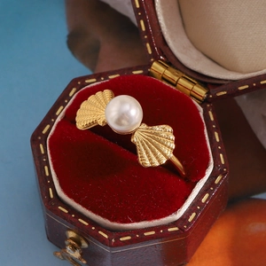 Détail d'une bague coquillage en perle plaquée or 18 carats dans un écrin en velours