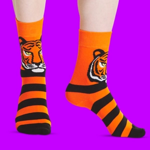 Detail of orange cotton socks with black stripes and tiger head pattern on purple backdrop