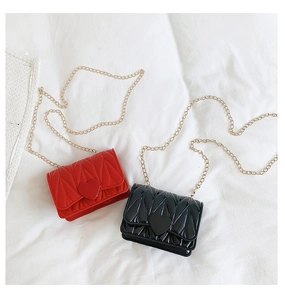 Detail of red and black mini heart purses with quilted pattern and gold chain straps